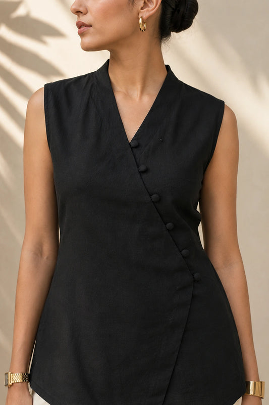 Close-up of black wrap kurta showing fabricated loop buttons and asymmetric wrap neckline detail