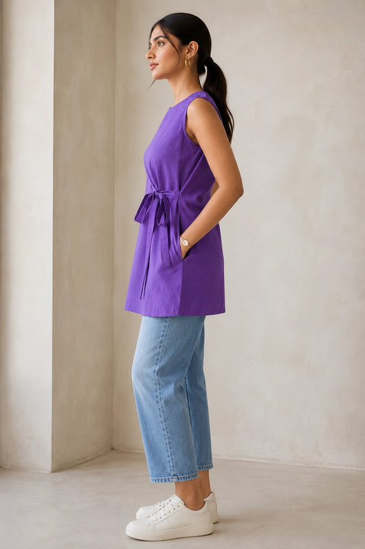 Side view of purple sleeveless kurta showing attached side-tie bow, side pocket and A-line silhouette