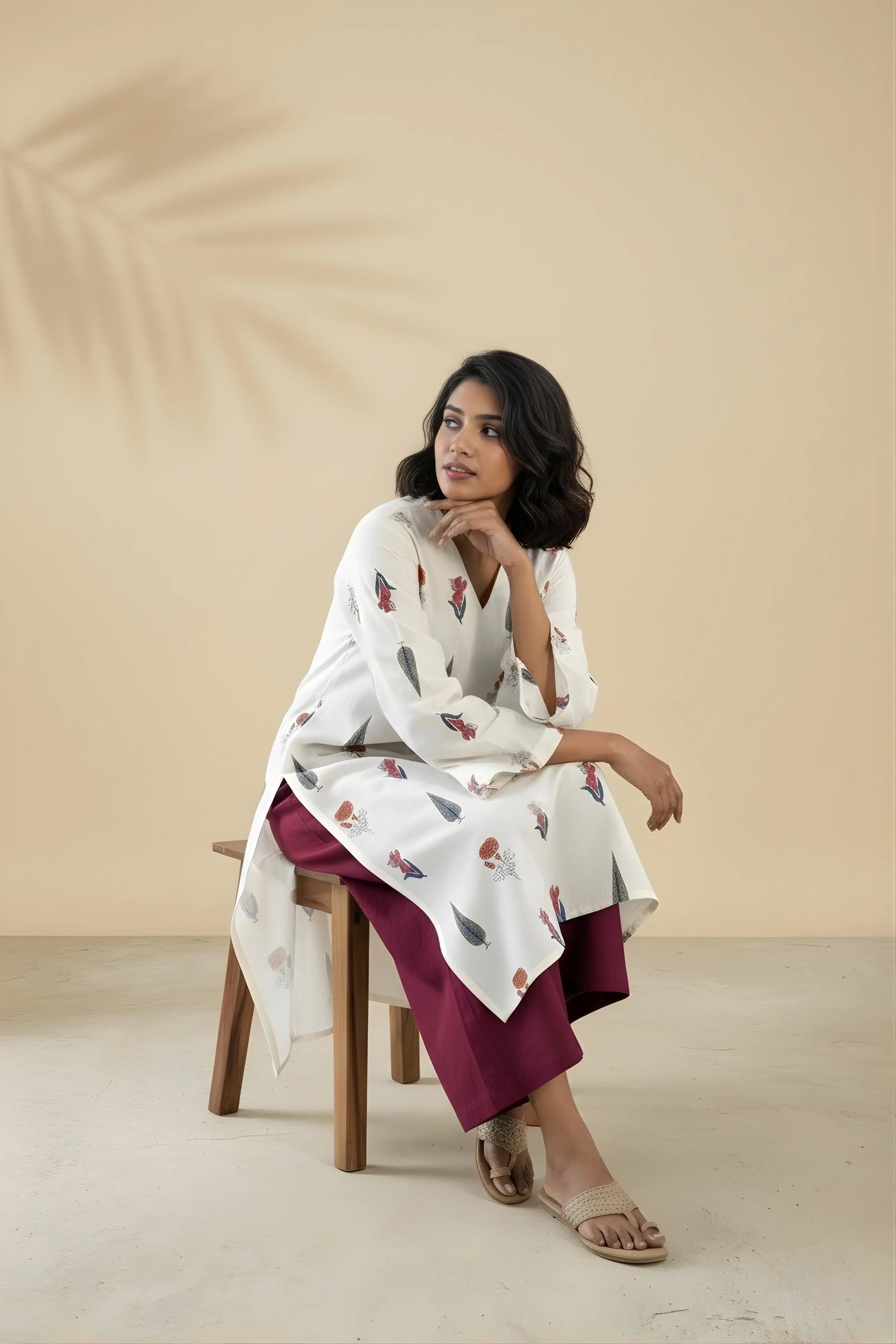 Model sitting on a chair wearing beige floral cotton office set