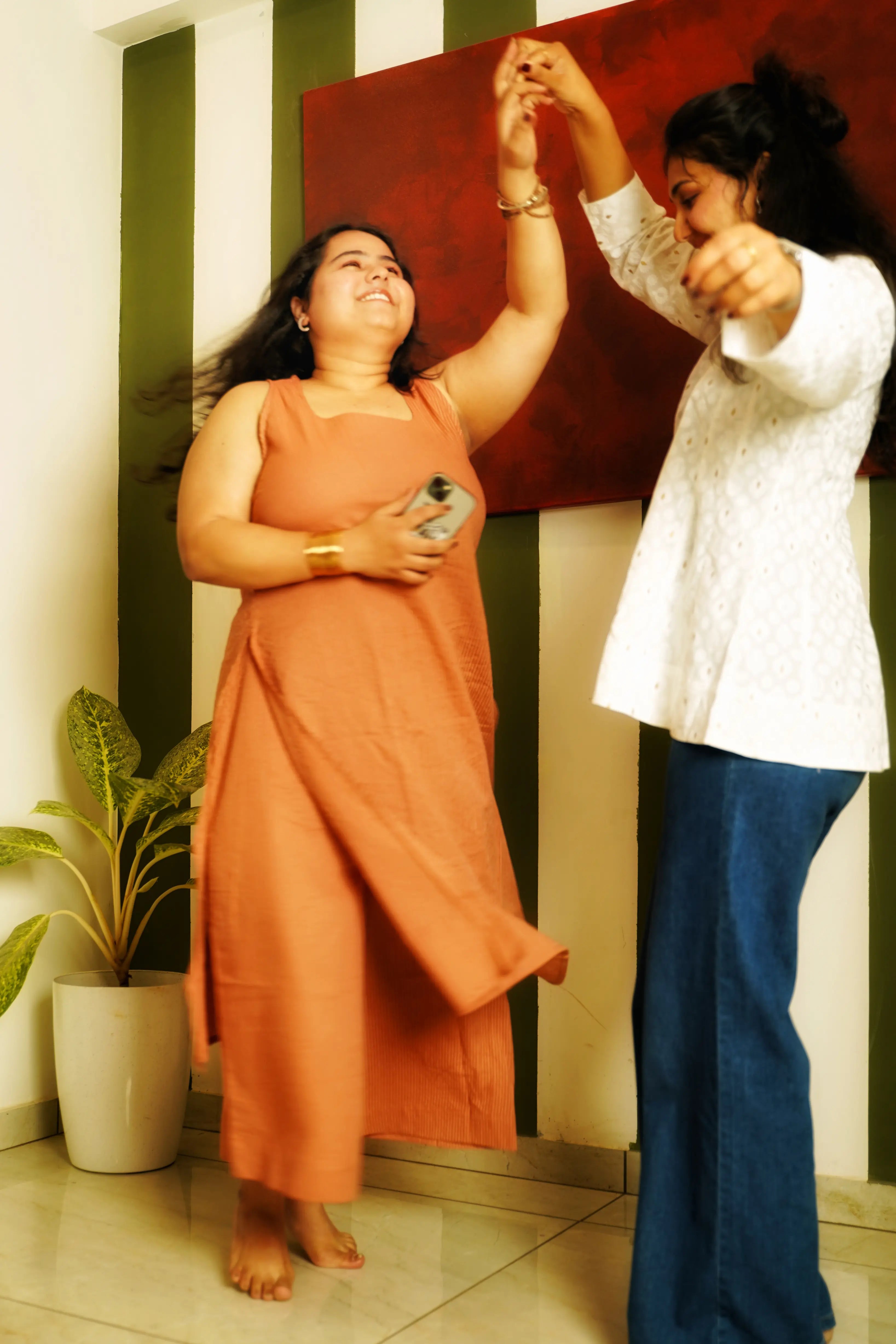 Women in Swayra contemporary Indian kurta sets dancing indoors, highlighting versatile workwear style that move easily from work to life.