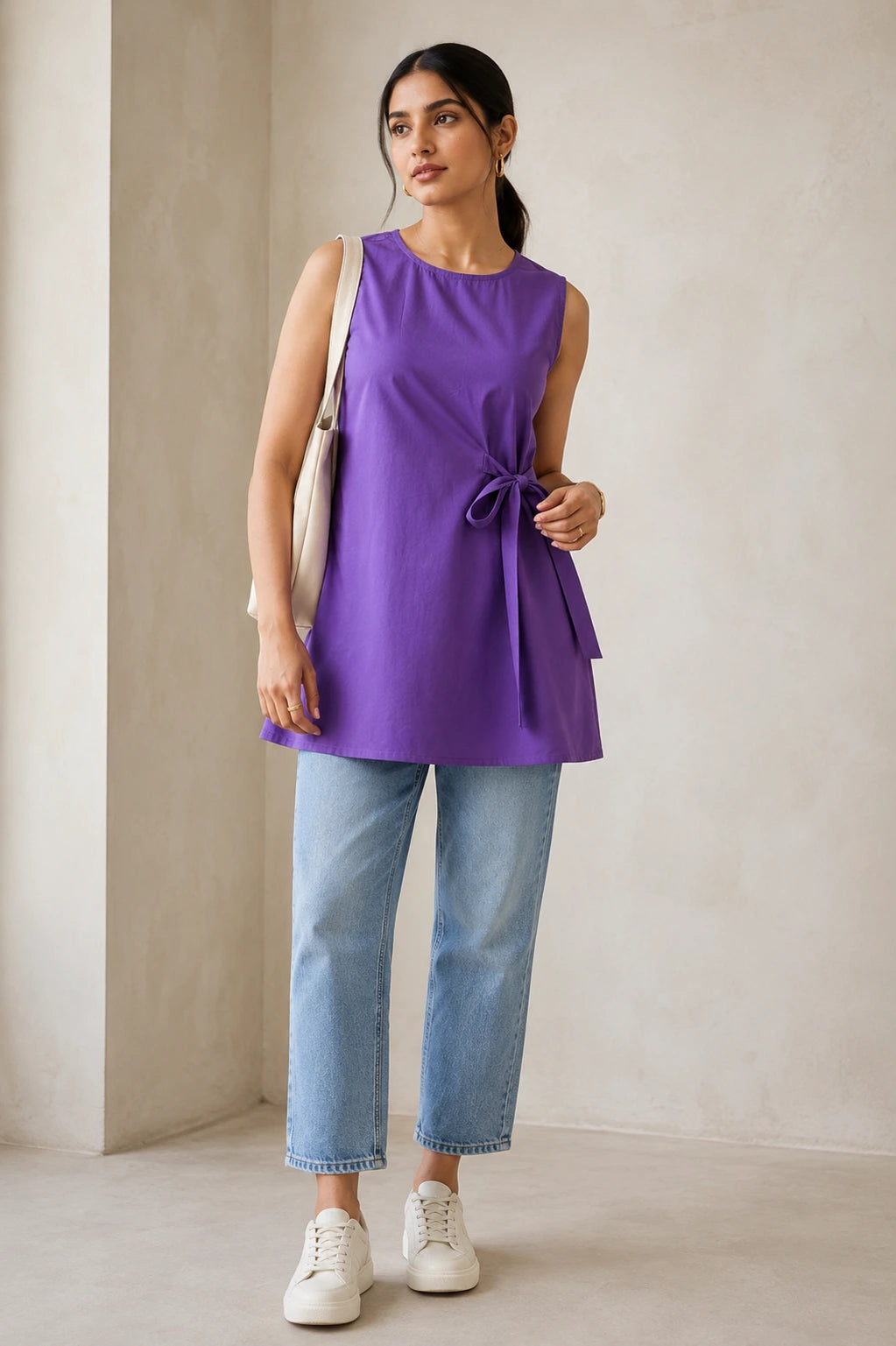 Purple side-tie kurta, full front view showing relaxed A-line fit and side-tie bow, styled with blue jeans and white sneakers