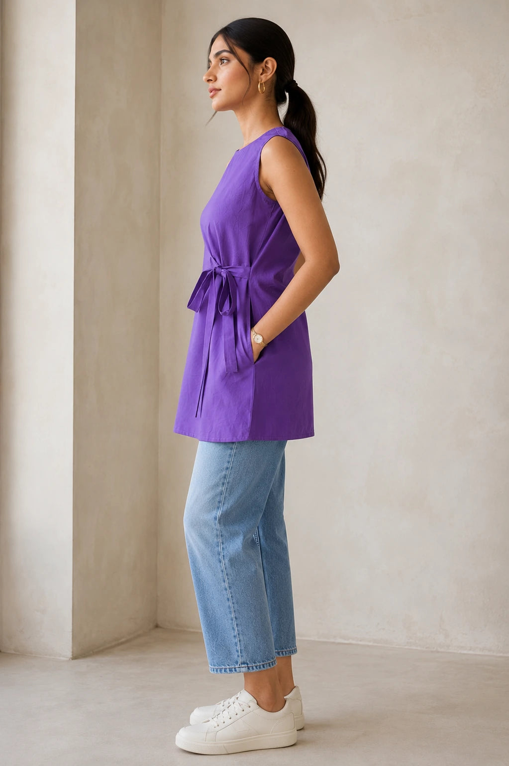 Side view of purple sleeveless kurta showing attached side-tie bow, side pocket and A-line silhouette