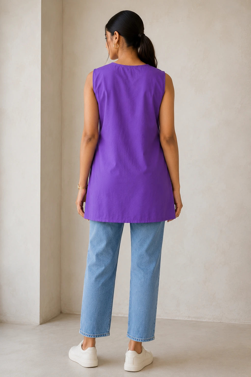 Purple side-tie kurta, back view showing clean straight hem and relaxed A-line silhouette, styled with blue jeans and white sneakers