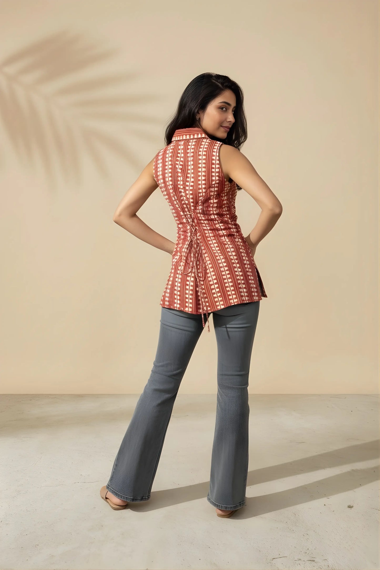 Back view of watermelon red short kurti styled with denim showing adjustable corset tie-up detail