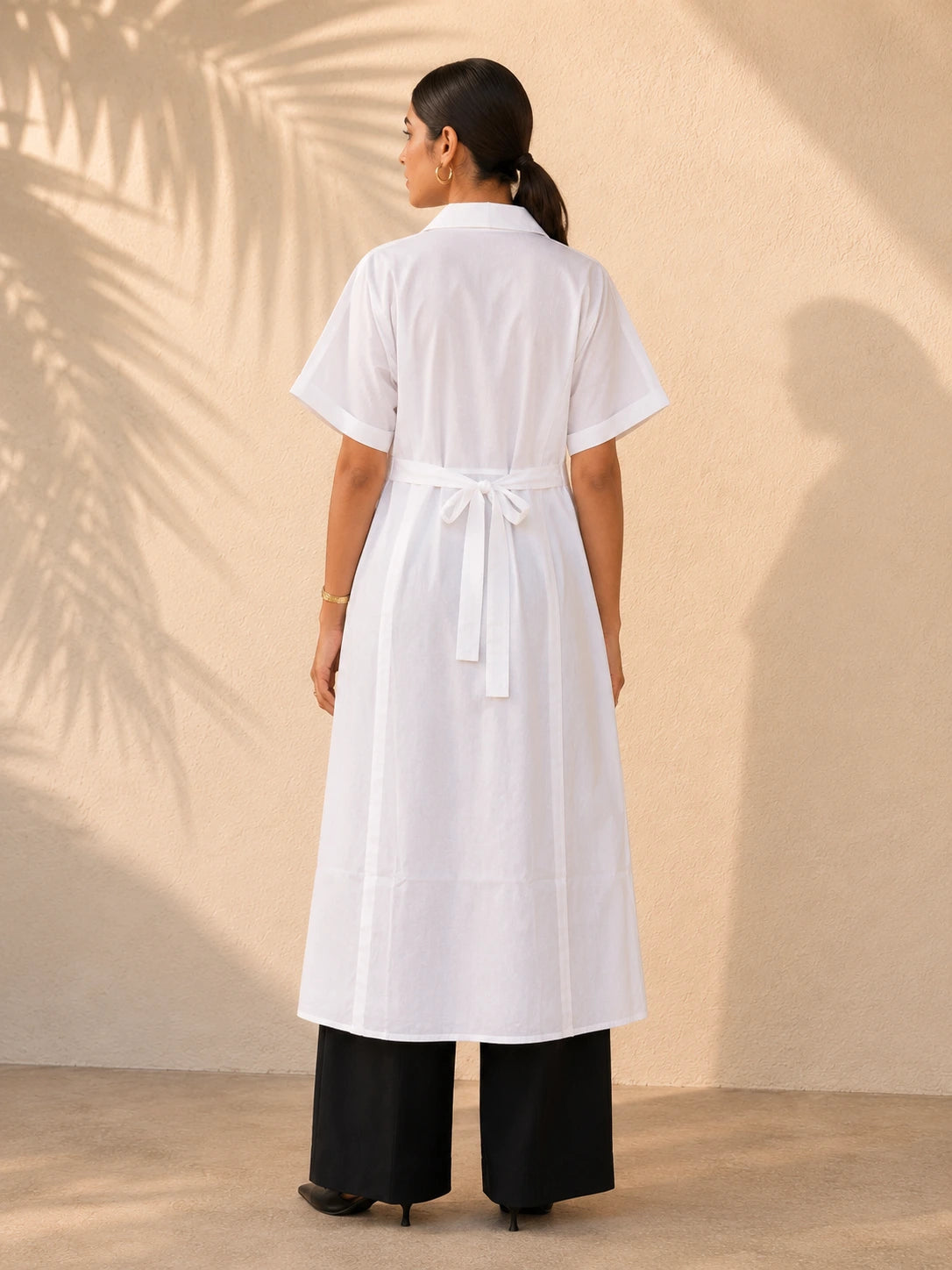 White A-line belted shirt kurta, back view showing self-tie belt at waist and longline A-line silhouette, styled with black wide-leg trousers