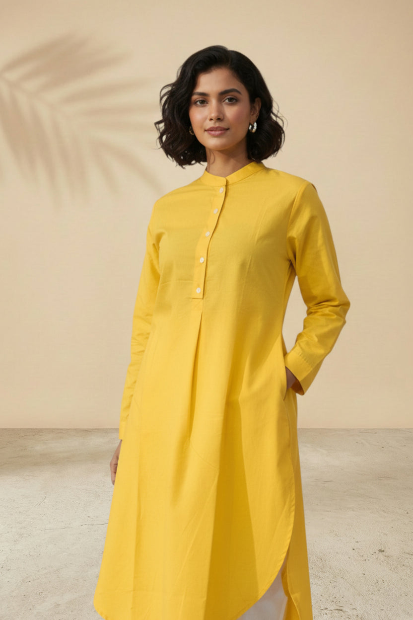 Upper body view of solid yellow pleated tunic showing neckline detail